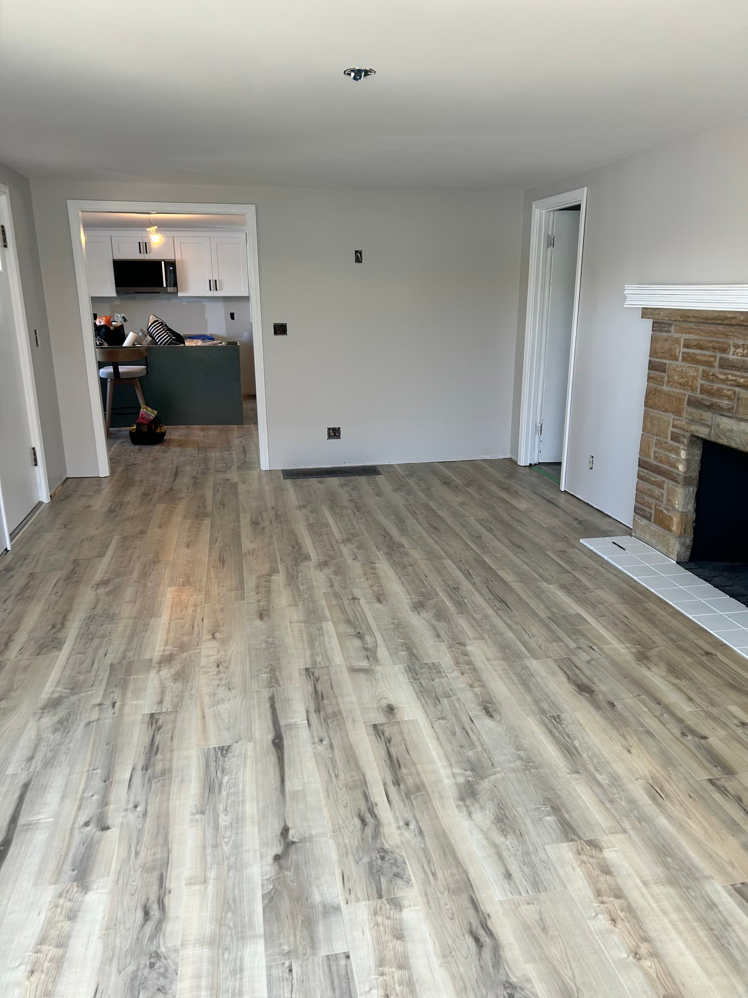 Finished living room with wood floors and brick fireplace