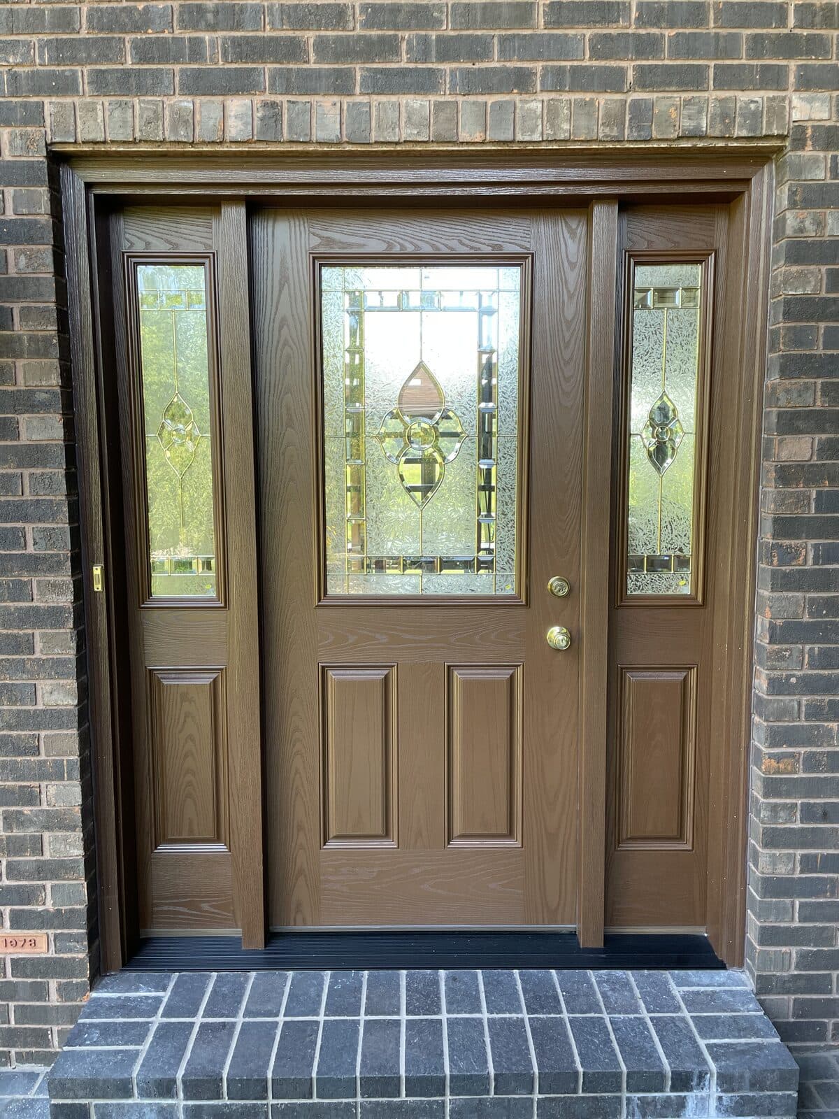 Stained six-panel entry door with decorative glass sidelights