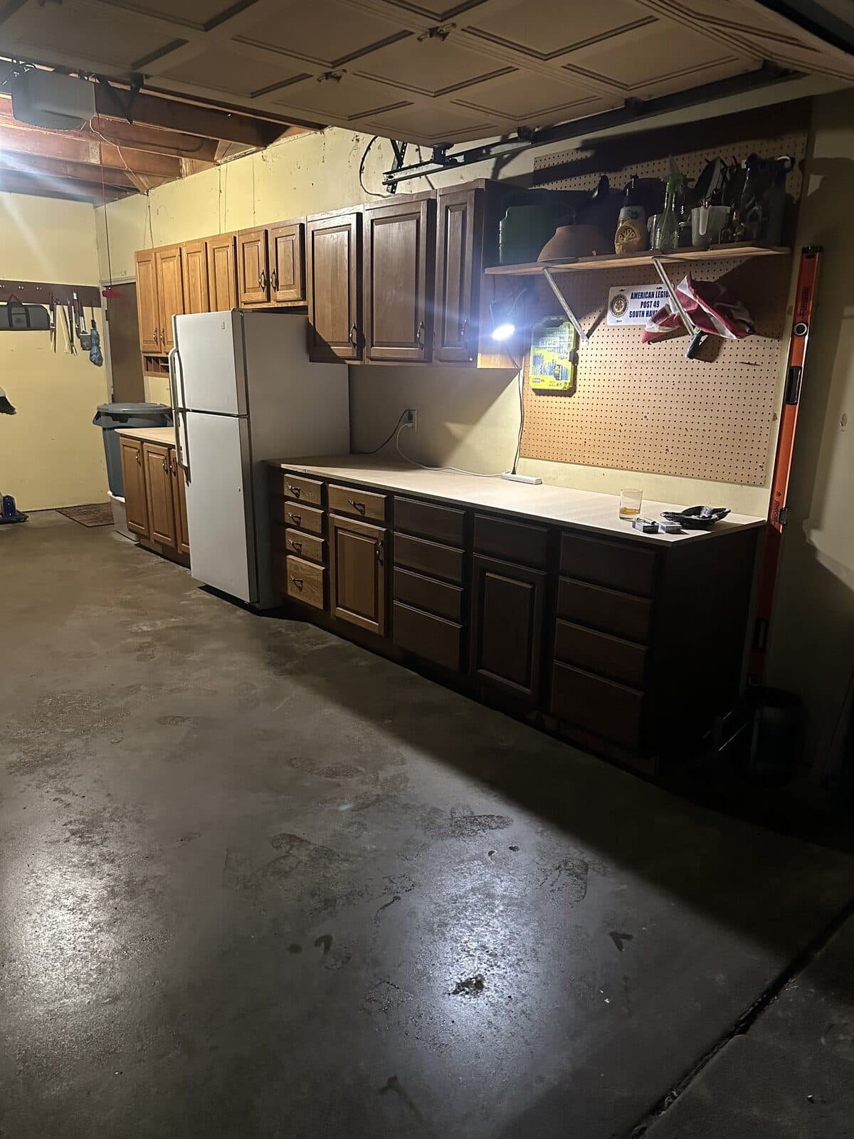 Finished garage workspace with stained cabinets and pegboard