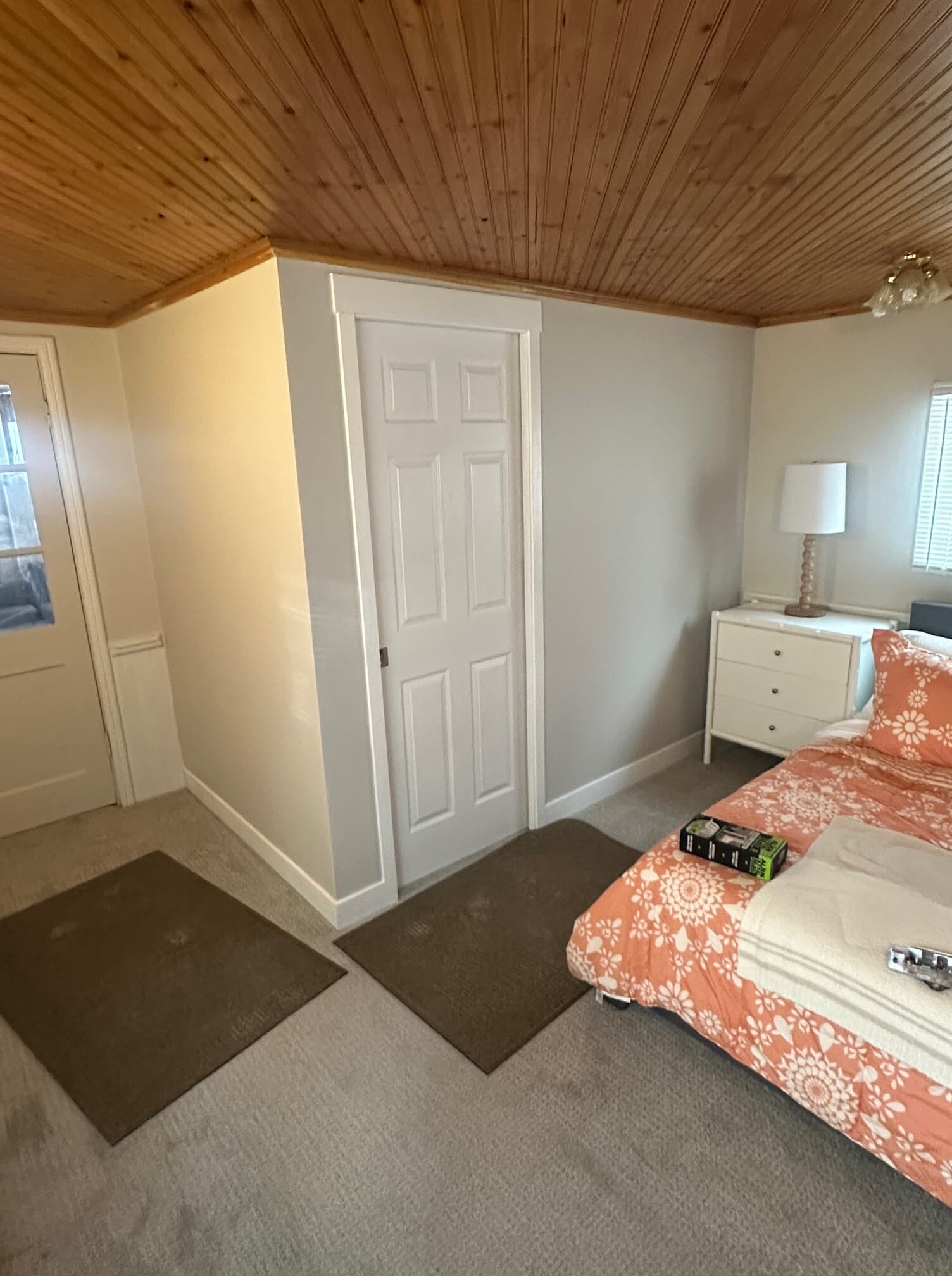 Lake cottage bathroom with sage-green vanity, framed mirror, and wood-look floor