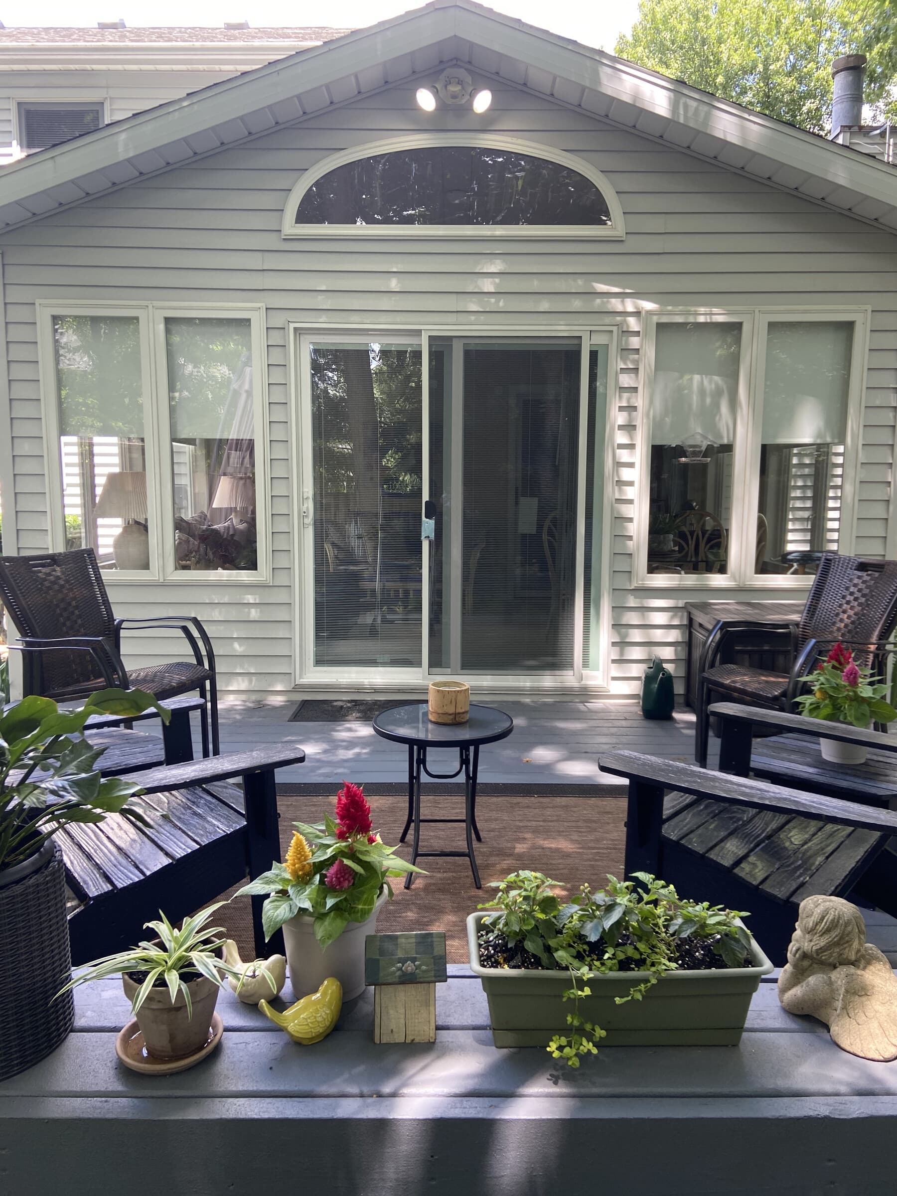 Side view of green-grey home with new slider, hostas, and summer landscaping