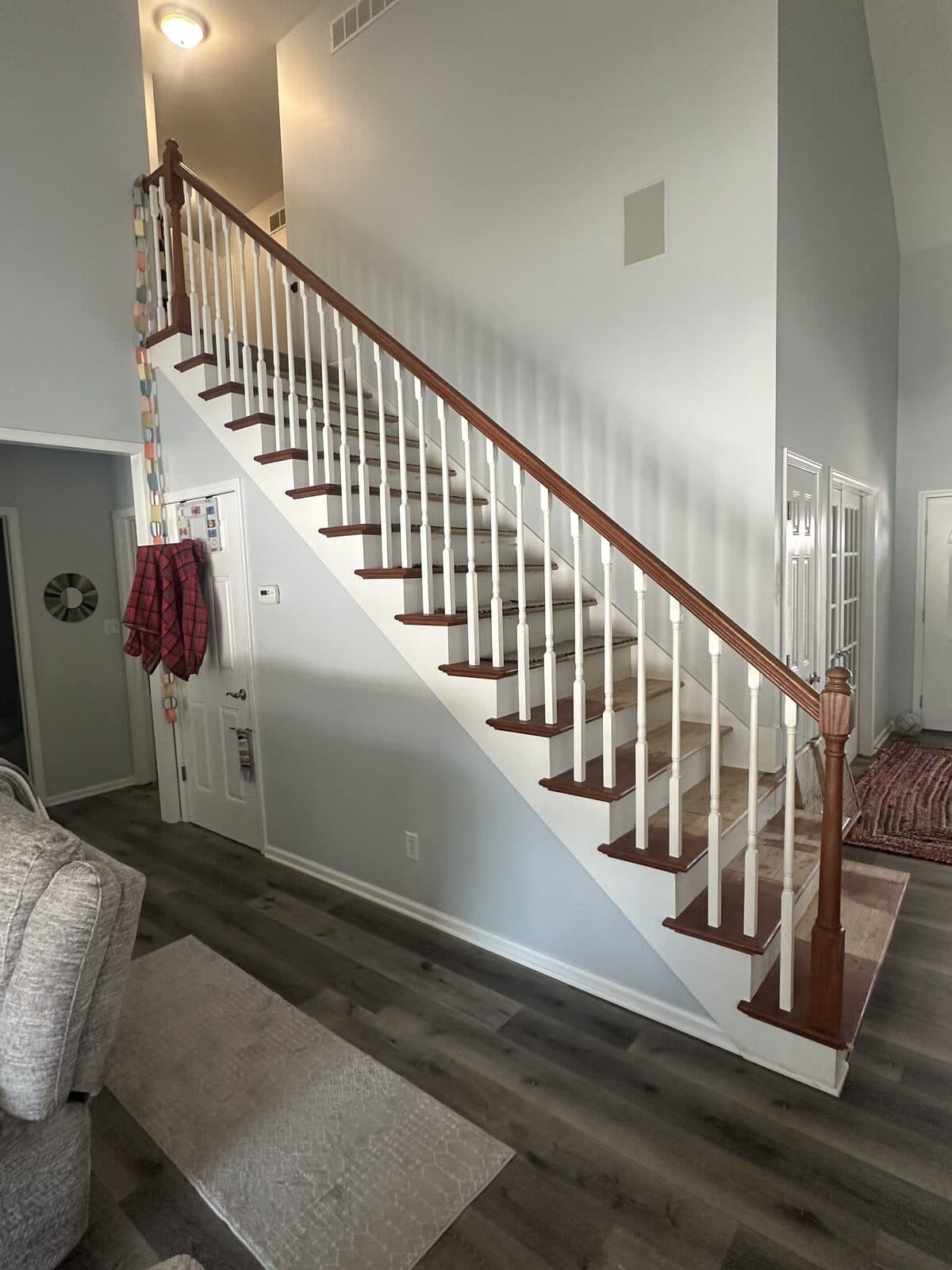 Open-tread staircase with white balusters and oak handrail